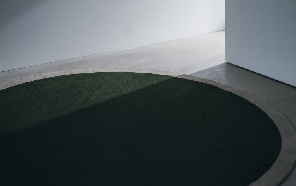 グリーンの丸いWOOLRUG「Frame」が床に置かれている