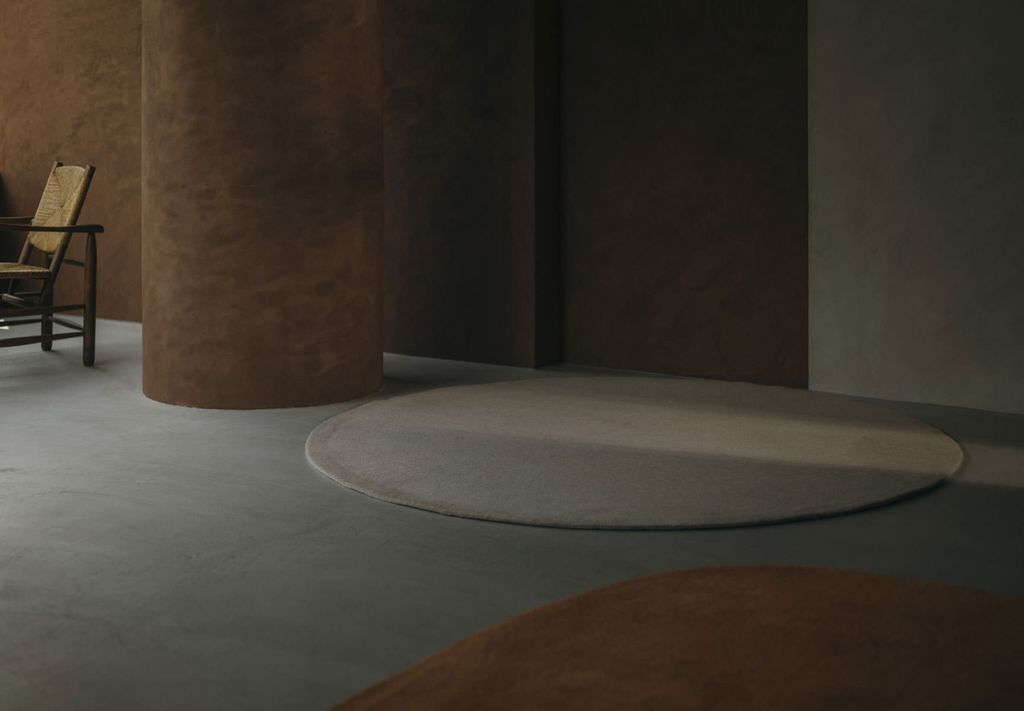 ブラウン調の室内にあるホワイトの楕円形のWOOLRUG