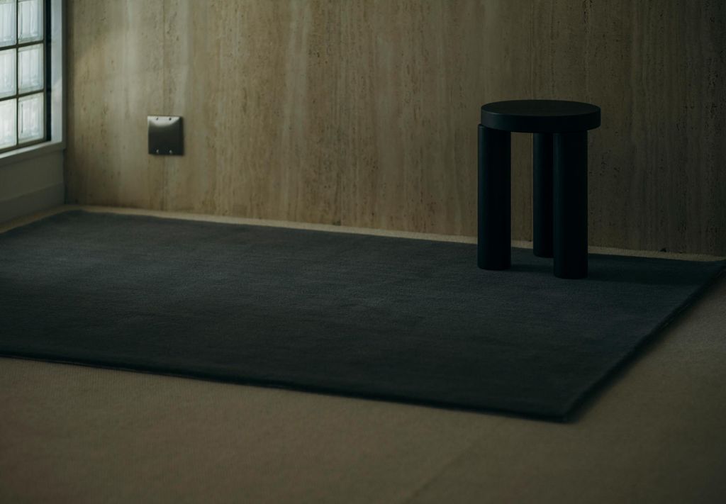 木目の壁と暗い色のWOOLRUG